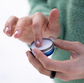 DERMATONE tin next to a credit card for size comparison and portability
