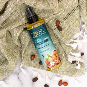 Desert Essence bottle in hand showing 8.28 fl oz scale and portability