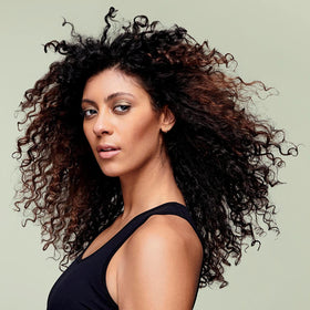 DevaCurl ingredient label close-up, highlights sulfate-free vegan formulation benefit
