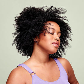 DevaCurl product applied in hand demonstrating slip and ease of detangling for curls