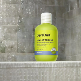 DevaCurl 12 fl oz bottle beside common items for scale and travel planning