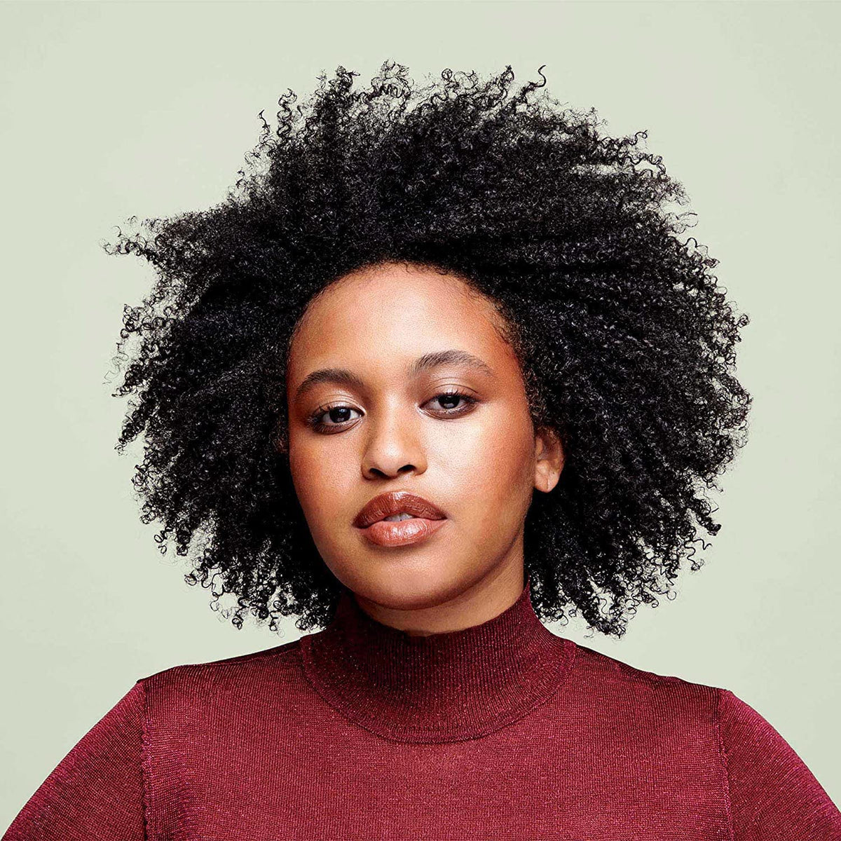 DevaCurl pouring cleanser from bottle to show non-lather usage benefit