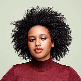 Applying DevaCurl SuperCream to damp curls for improved definition and frizz control