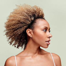 DevaCurl being applied to wet curly hair to speed detangling and reduce pulling