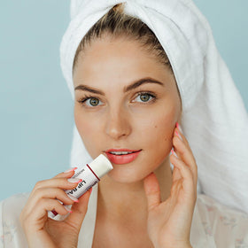 Dmsky applying balm to hand to demonstrate creamy texture and quick absorption