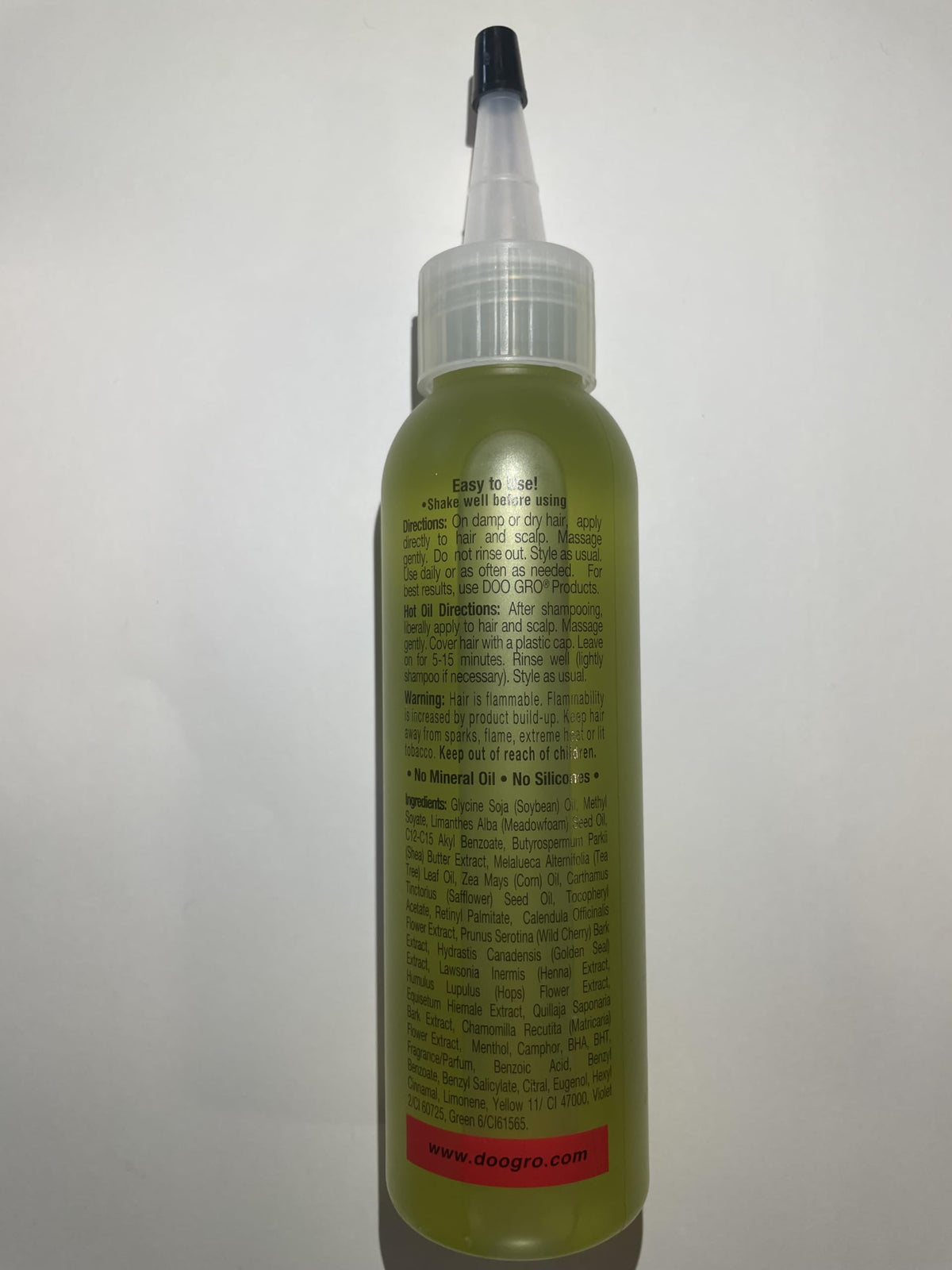 DOO GRO bottle next to coin showing compact travel-friendly size