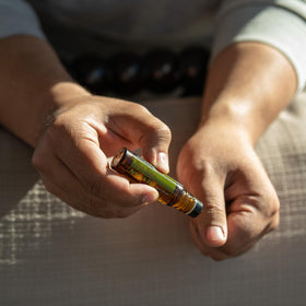 doTERRA Melaleuca Touch in hand for scale demonstrating portable 10 mL size