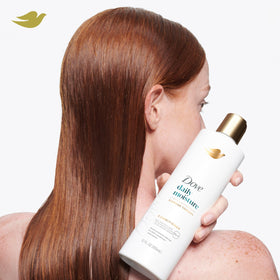 Dove conditioner being applied to wet hair showing detangling benefit