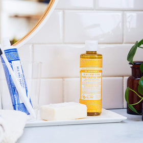 Dr. Bronner's citrus being poured into hand, showcasing concentrated use and economy