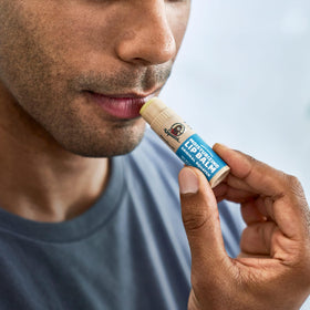 Dr. Squatch Coconut Cove tube in beach setting evoking tropical hydration