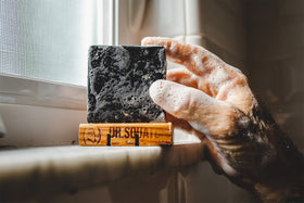 man in shower using Dr. Squatch pine tar soap for deep clean and fresh scent