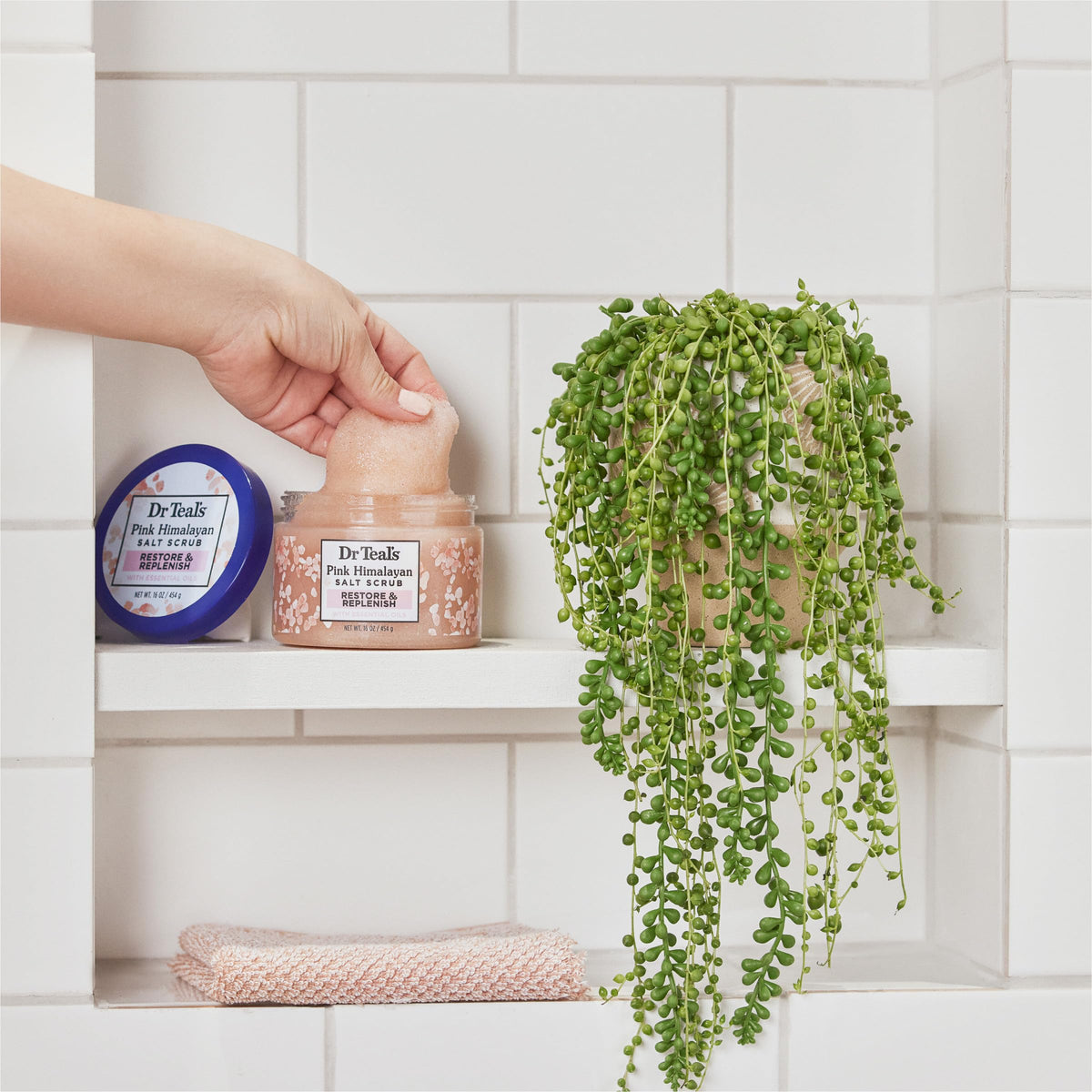Dr Teal's 16 oz jar next to hand to show actual product size