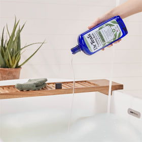 Dr Teal's 34 fl oz bottle held next to hand for size and scale clarity