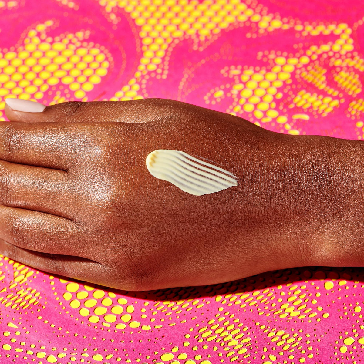 Drunk Elephant cream applied on hand demonstrating easy blending and hydration