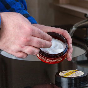 Duke Cannon hand applying balm to knuckles for fast relief