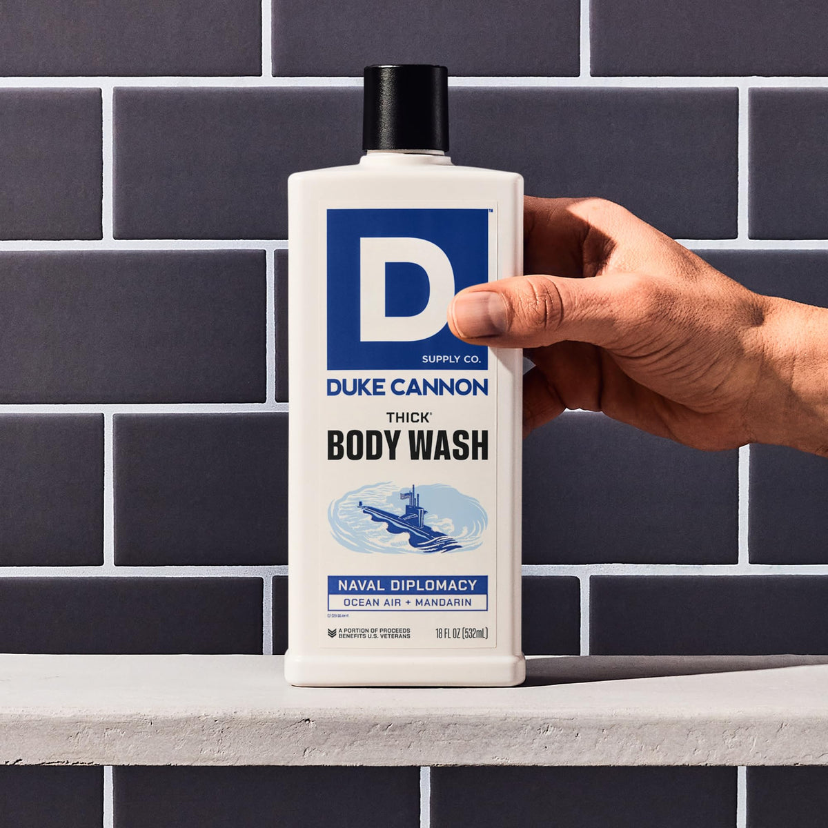 Duke Cannon bottle in hand showing scale and generous volume benefit