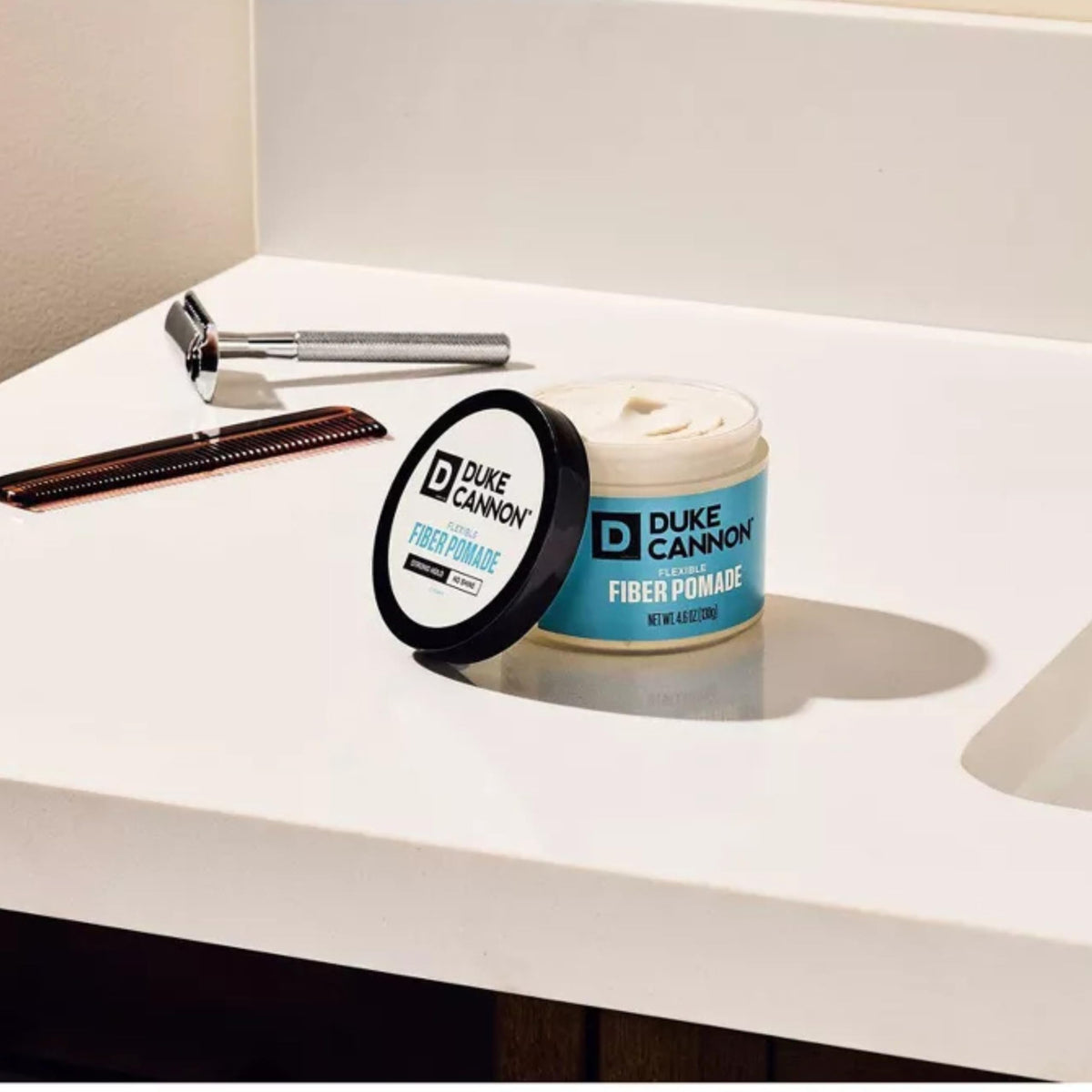 Duke Cannon pomade held in hand for scale indicating travel-friendly size