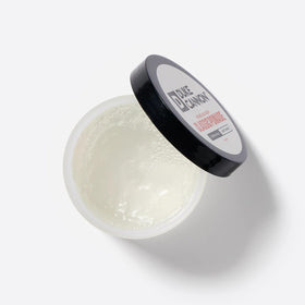 Close-up of Duke Cannon pomade texture on finger demonstrating smooth spreadability and control