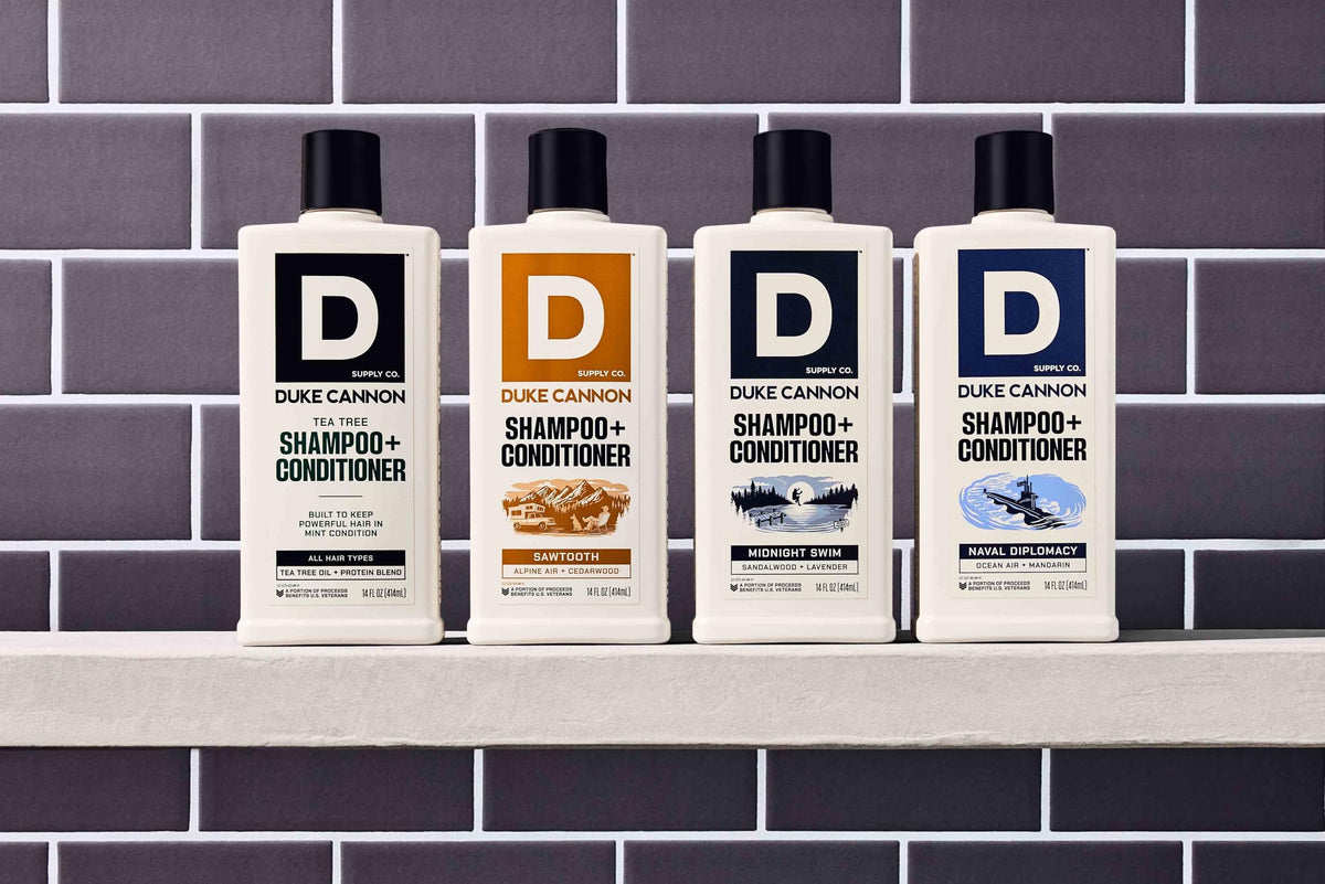 Duke Cannon bottle held in hand to show 14 oz scale and travel convenience benefit