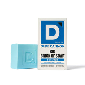 Duke Cannon Superior bar pictured with wood tones conveying deep, warm woody scent