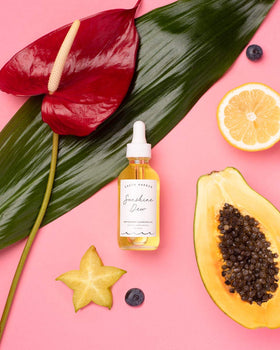 Earth Harbor bottle next to hand to show 2 fl oz size and travel-friendly benefit