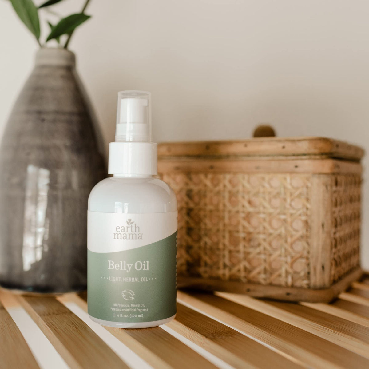 Earth Mama belly oil beside common items indicating 4 fl oz size benefit