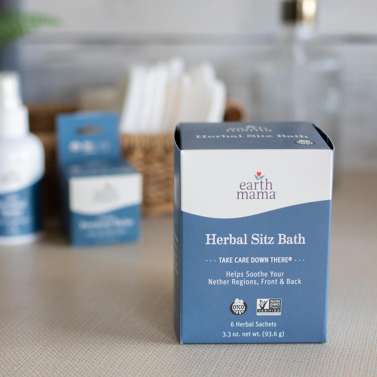 Hand holding sachet next to a sitz basin showing Earth Mama sachet size and scale