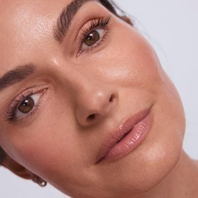 EarthsCure highlighter swatch on cheek showing luminous finish