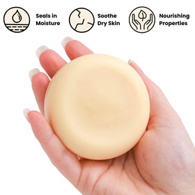 ECO ROOTS lotion bar next to a hand for scale illustrating travel-ready compact size