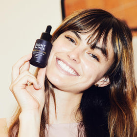 Eight Saints applying serum on hand to show lightweight absorption benefit