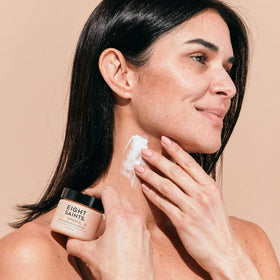 Eight Saints applying cream to neck demonstrating lift and targeted firming