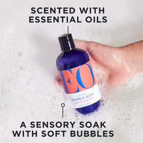 EO bottle being poured into running tub creating bubbles for relaxing soak