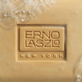 Erno Laszlo bar next to ruler showing 3.4 fl oz scale and travel convenience benefit