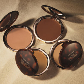 Estée Lauder bronzer swiped on cheek showing natural bronze finish benefit: adds warm dimension