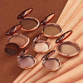 Estée Lauder bronzer blended on shoulders and décolletage showing body use benefit: cohesive sun-kissed look