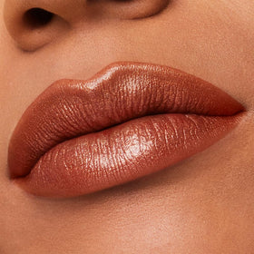 Estée Lauder swatch of 111 Tiger Eye on forearm showing true shimmer and wearable tone benefit