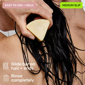 Ethique conditioner bar being applied to hair ends showing detangling and smoothing benefit