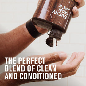 Every Man Jack bottle next to hand showing scale of the 24 fl oz travel-friendly size