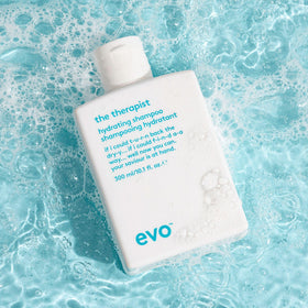 EVO The Therapist bottle next to everyday objects showing 10.1 fl oz scale