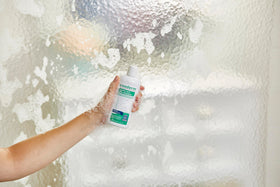 Person applying Exederm in shower demonstrating calming scalp care