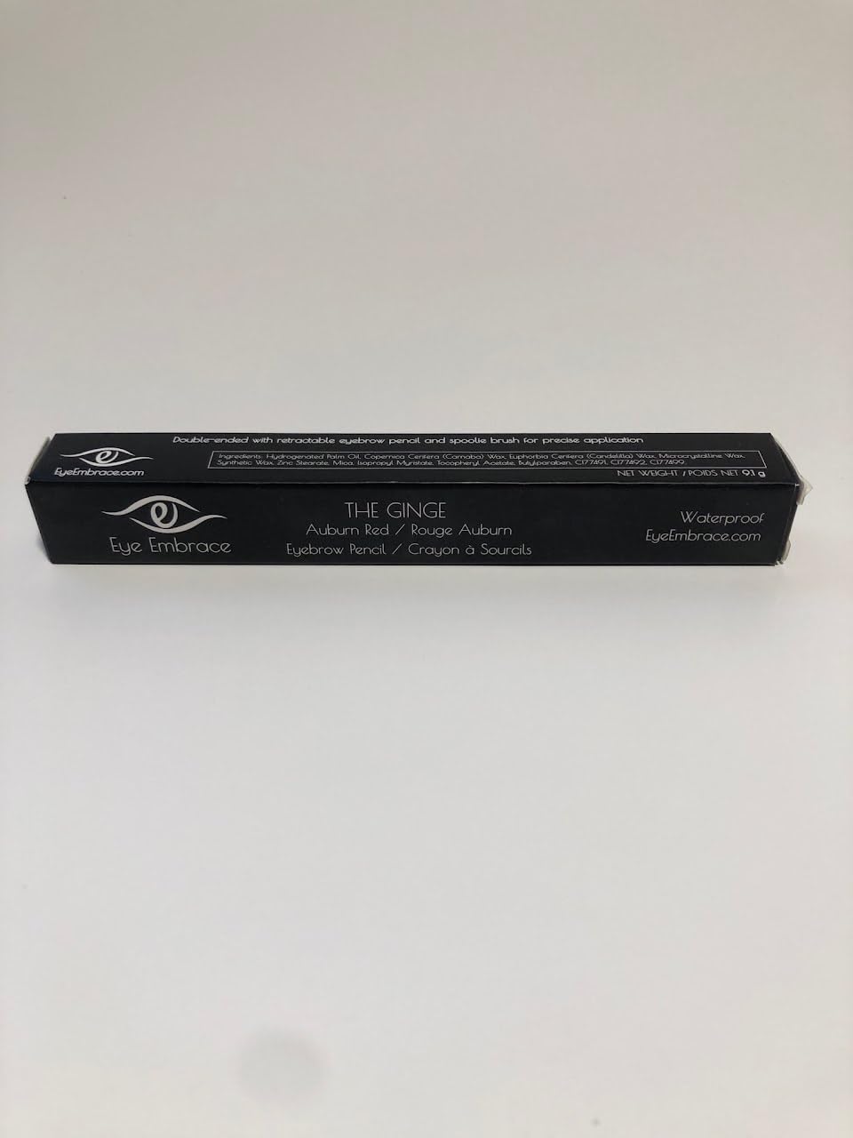 Eye Embrace pencil next to coin showing compact travel-friendly size