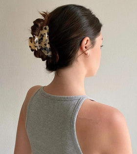 Eyegla lifestyle shot of model wearing clip showing effortless hairstyle and polished style