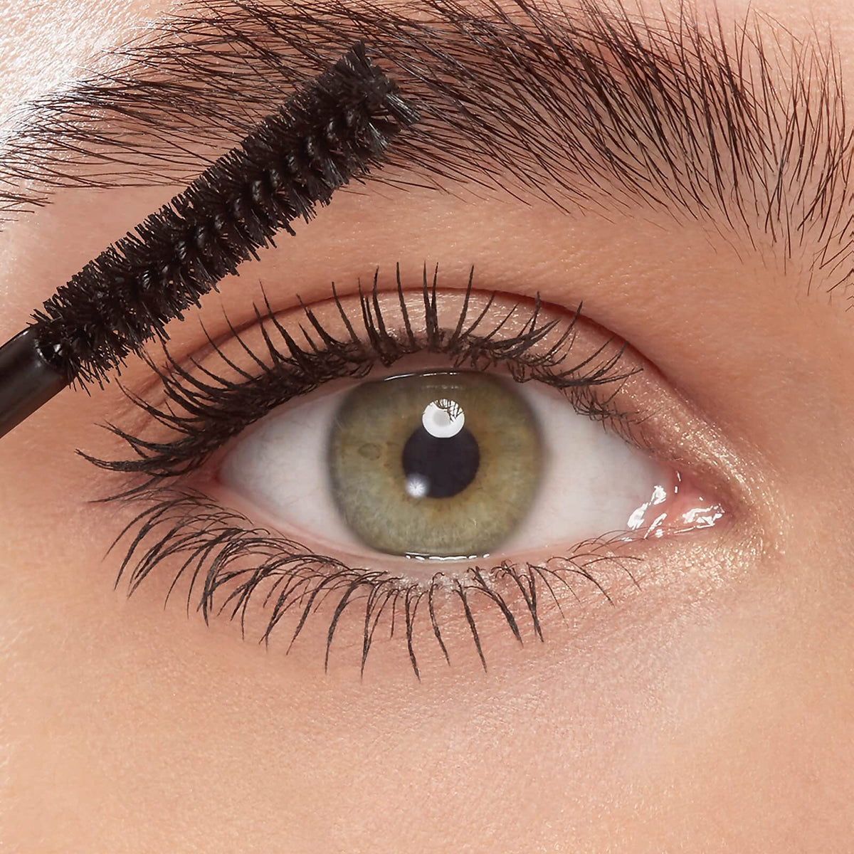 Eyeko mascara in hand to show travel-size scale and easy-packing benefit