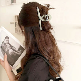 FAELBATY clip beside a ruler showing 5.1-inch size to demonstrate capacity for thick hair