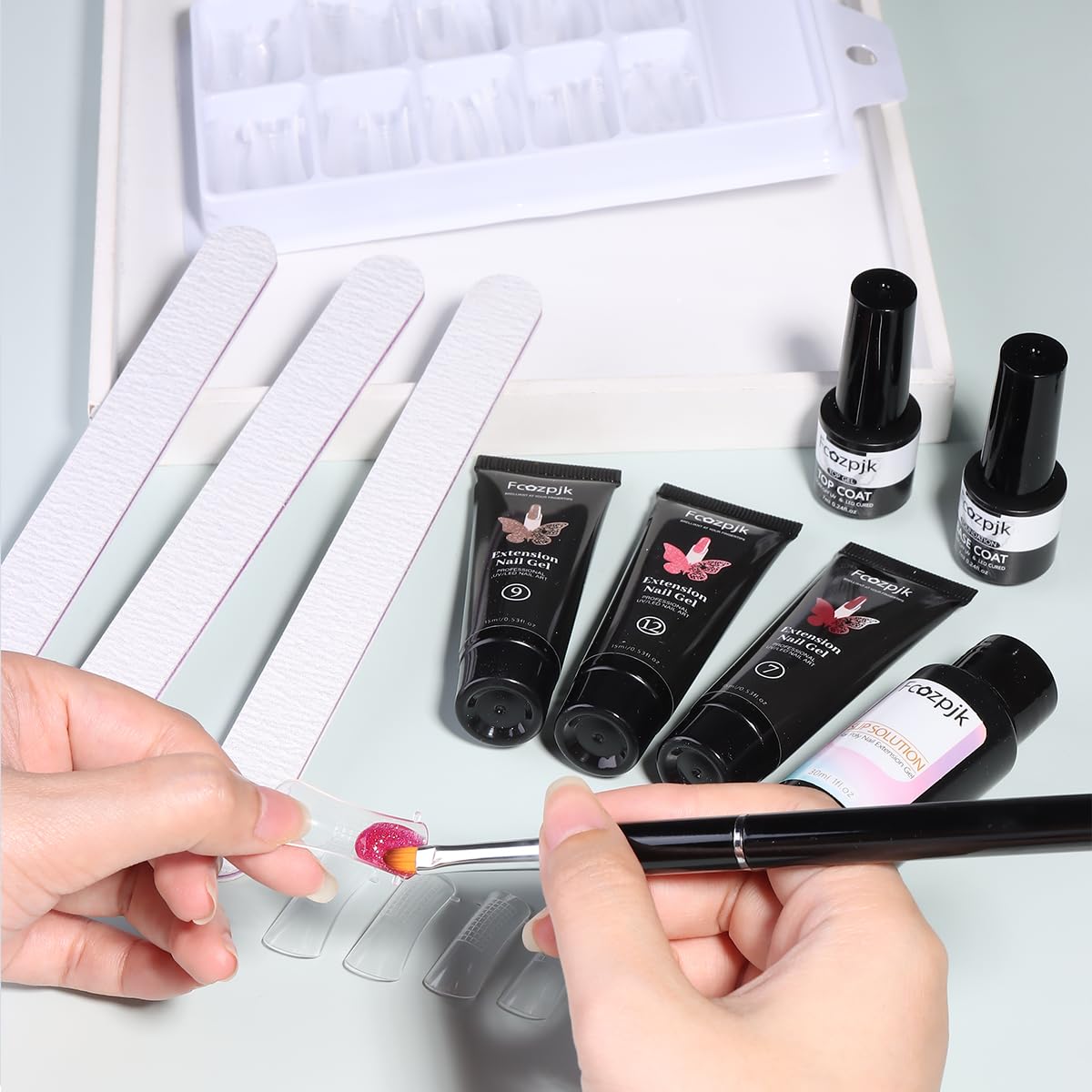 Fcozpjk hand applying poly gel with brush demonstrating smooth, controlled sculpting