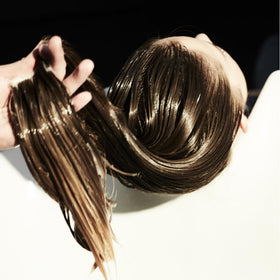 Fekkai being applied to hair mid-lengths to tame frizz and add shine