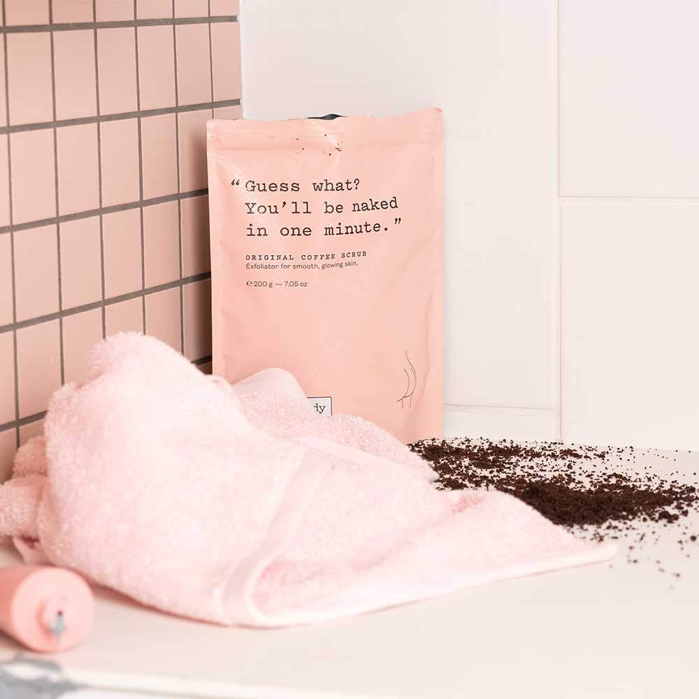 frank body flatlay with coffee beans almond oil and sea salt showing natural ingredients