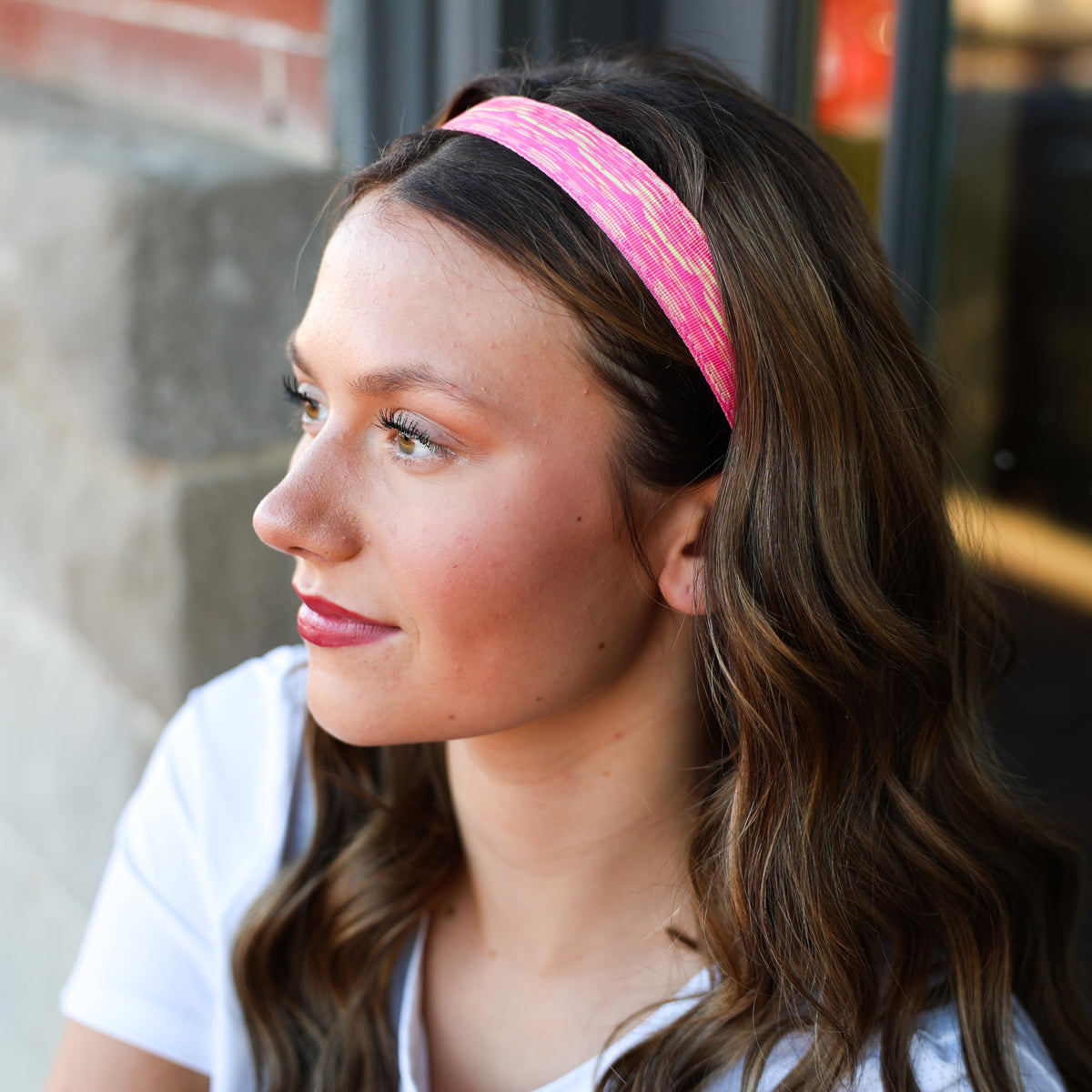 Young girl wearing FROG SAC headband playing soccer showing active stay-put benefit