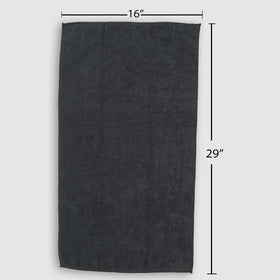 Fromm towel beside hand showing 16 by 29 inch size and portability