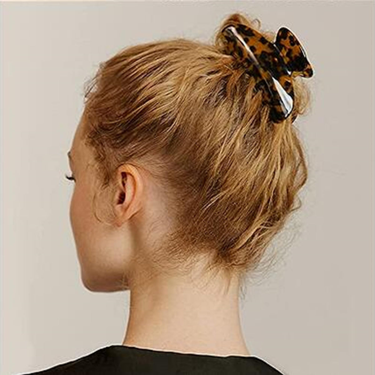 Fsmiling clip securing a woman's bun for quick polished hairstyle